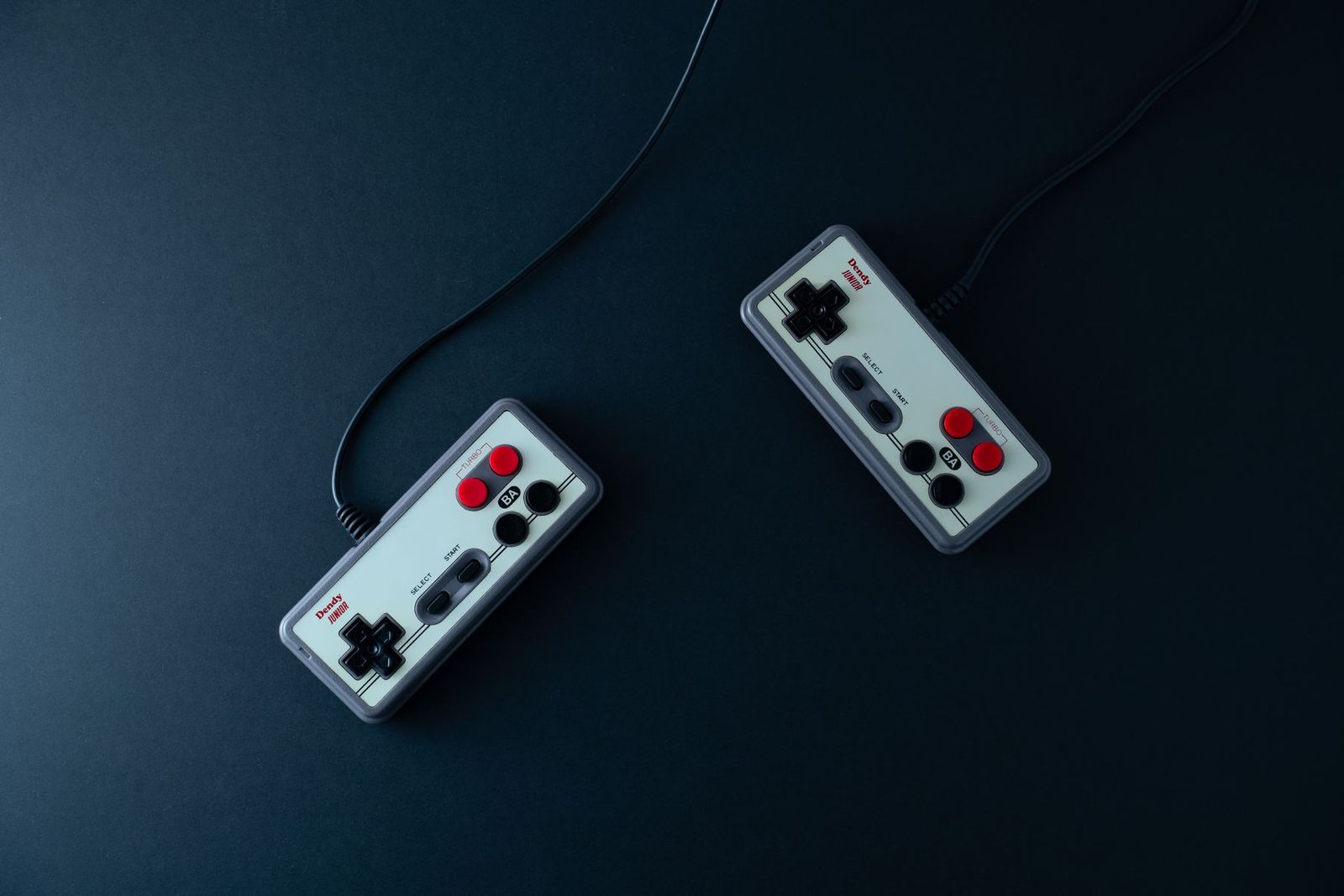 黒い背景に置かれた2つのレトロゲームコントローラー