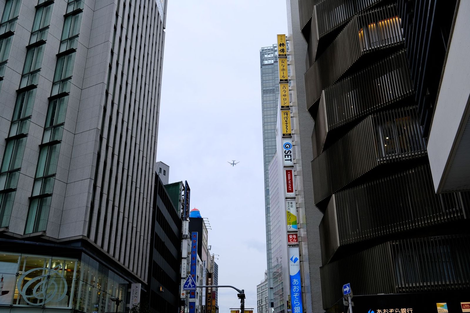 高層ビルと飛行機が見える渋谷の街並み